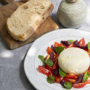 burrata com tomatinho cereja, azeitona preta e hortelã com pão de fermentação natural, orgânico